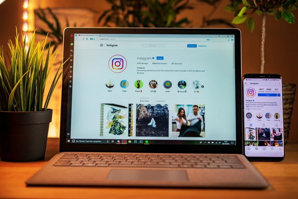 A computer on the table showing an Instagram profile