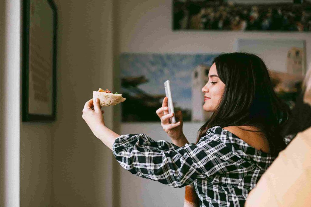 micro influencer woman taking picture of food